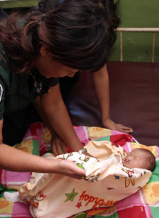 A doctor examines the abandoned baby boy with a cleft palate at a local police station in Shenyang, capital of Northeast China's Liaoning Province. [newsphoto]