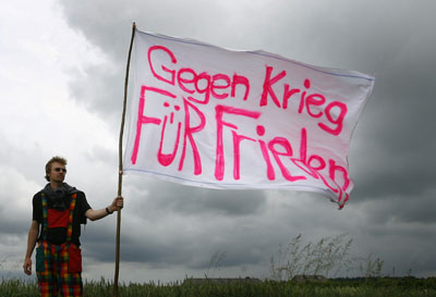 An anti-G8 demonstrator holds a placard reading 