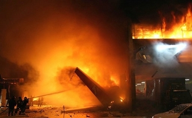 Firefighters try to extinguish a fire at the site where a TAM airlines commercial jet crashed in Sao Paulo, Tuesday, July 17, 2007. The plane with as many 170 people aboard crashed and burst into flames in Sao Paulo after skidding off a runway that has been criticized as being too short in a driving rain, the nation's airport authority said. 